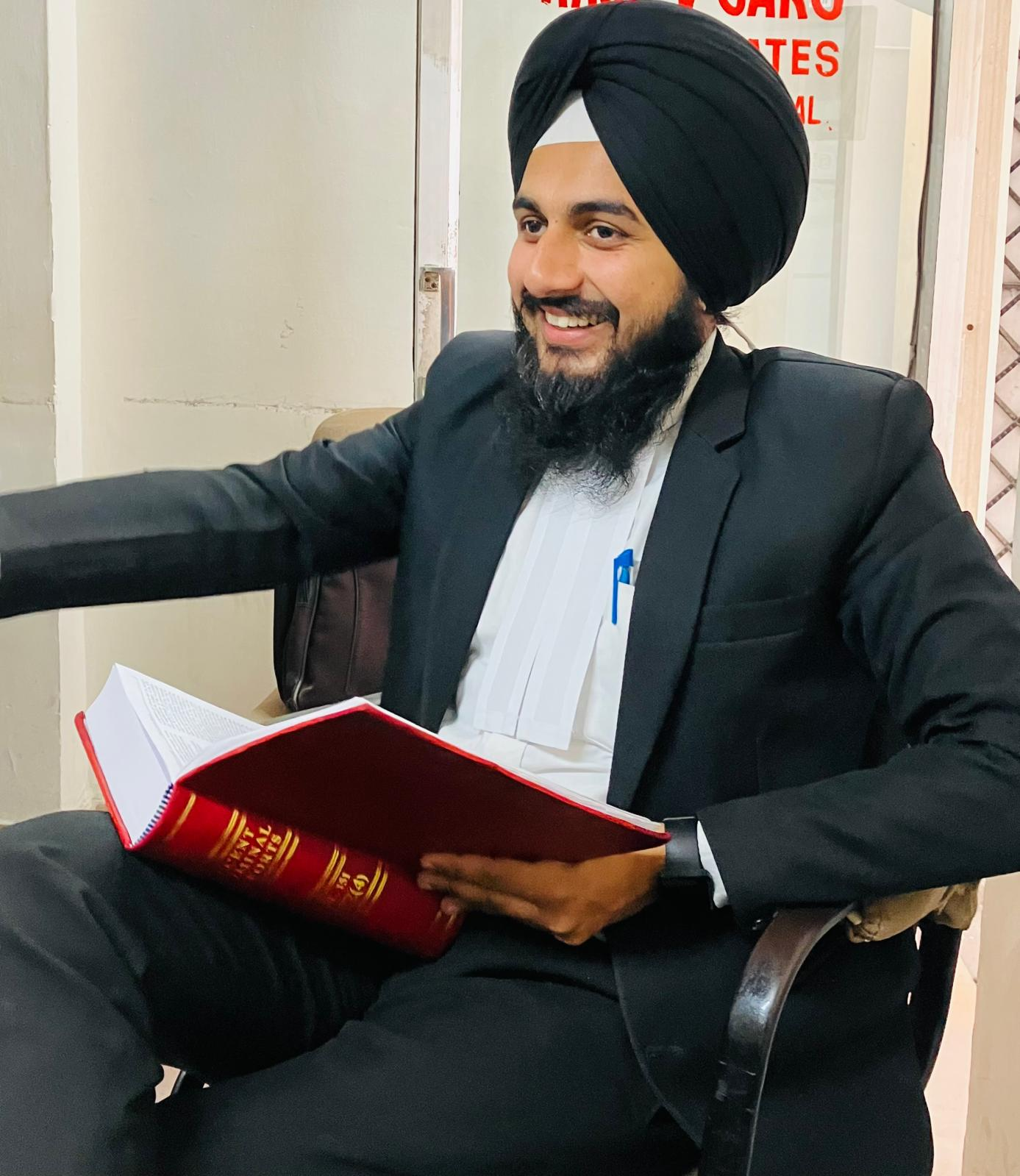 Prabhjot Singh in advocate attire holding a legal volume